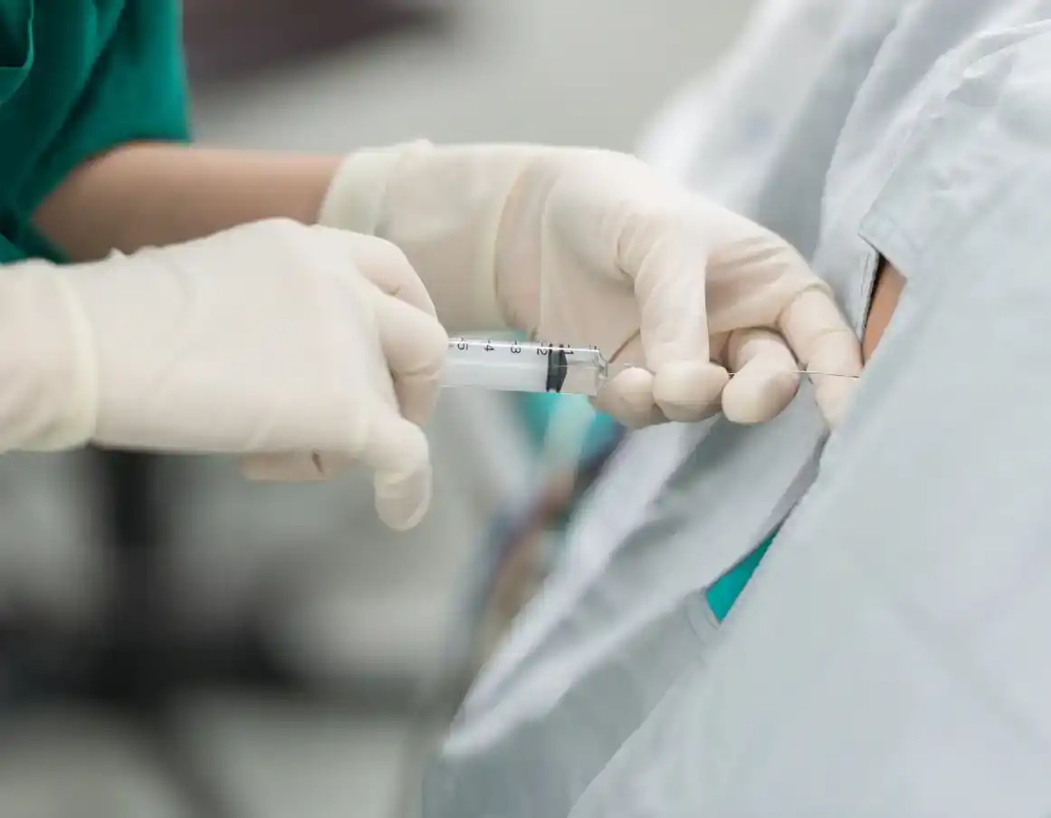 Close up shot of doctor administering epidural to pregnant woman for pain relief going into labor