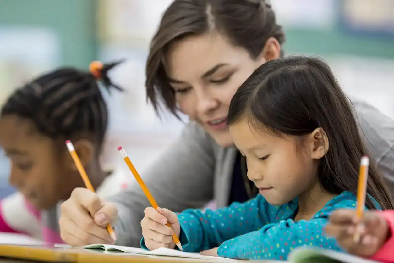 Teacher teaches young students how to spell