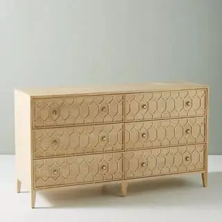 Tekstureret trellis-kommode med seks skuffer mod en grå baggrund.