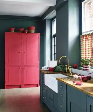 Cuisine bleue, placard rouge et rose, éléments gris, évier majordome