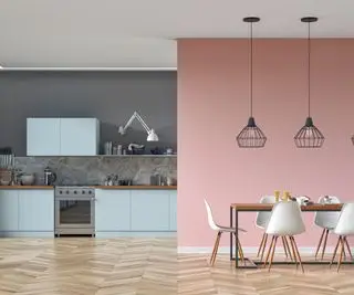 Une cuisine avec un mur rose et des armoires bleues