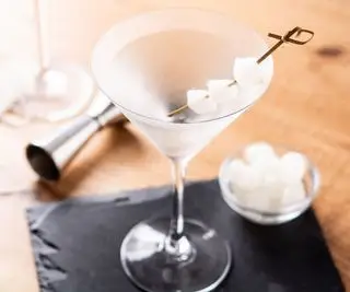 Kieliszek do martini z łupkiem i jiggerem w tle