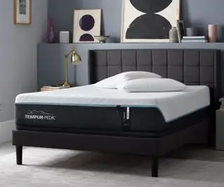 Matelas Tempur-Pedic ProAdapt contre un mur bleu-gris.