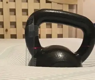 Une kettlebell sur un matelas Tempur-Pedic.