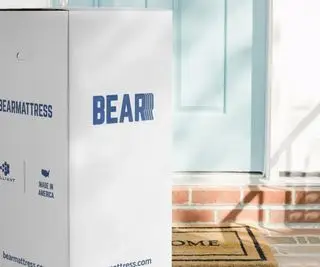 Materasso dell'orso in una scatola fuori da una porta d'ingresso azzurra.