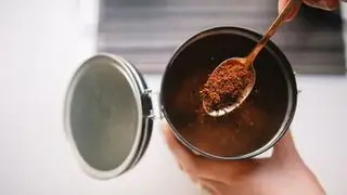 i fondi di caffè vengono raccolti da un barattolo con un cucchiaino