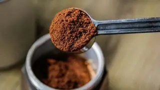 Fondi di caffè in un misurino sopra un barattolo di caffè