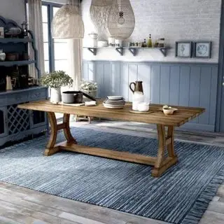 Un lungo tavolo da pranzo in legno in una cucina blu