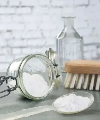 Um recipiente com bicarbonato de sódio ao lado de uma escova