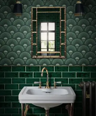stili di interior design senza tempo, bagno verde in stile art deco, carta da parati a ventaglio verde, rubinetto dorato, specchio dorato, applique dorate e nere, piastrelle verdi