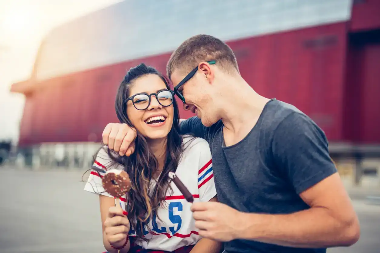 9 years old couple enjoy outdoors. They are eating ice cream after shopping