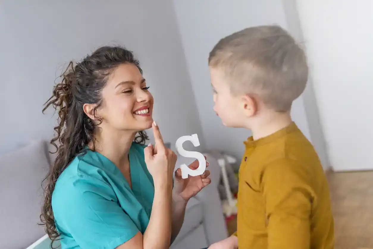 Speech therapist and little patient training articulation