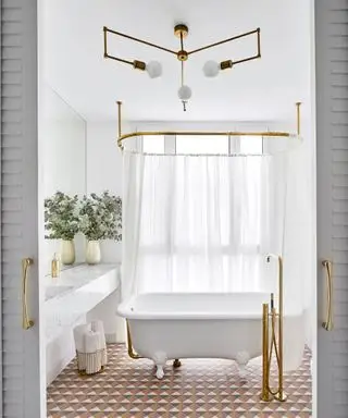Ein Badezimmer mit einer freistehenden weißen Badewanne und geometrischen Bodenfliesen