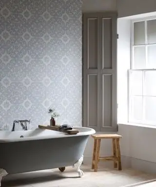 Kleine Ideen für Badezimmerfliesen, die eine graue freistehende Badewanne mit dekorativen grauen und weißen Wandfliesen zeigen