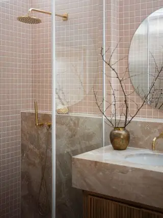 Korallenbad mit Dusche und Waschtisch mit Marmorplatte. Glastüren