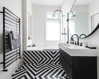 Ein monochromes Badezimmer mit optischen Täuschungsfliesen und einem schwarzen Heizkörper