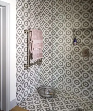 Um box amplo com azulejos estampados repetidos nas paredes e no chão