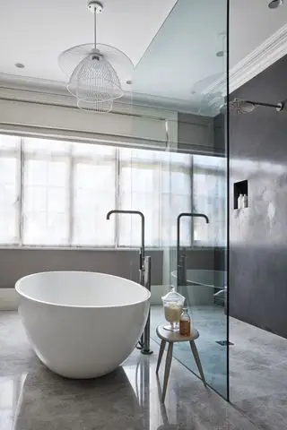 banheiro moderno com design em plano aberto, piso polido, banheira branca, box amplo, parede de box de vidro, pendente branco