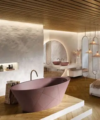 Banheiro amplo e luxuoso com teto e iluminação com painéis de madeira, paredes texturizadas pintadas de branco, banheira oval em cima de plataforma de madeira em camadas, espelho grande arredondado e dois espelhos ovais, coleção de pingentes