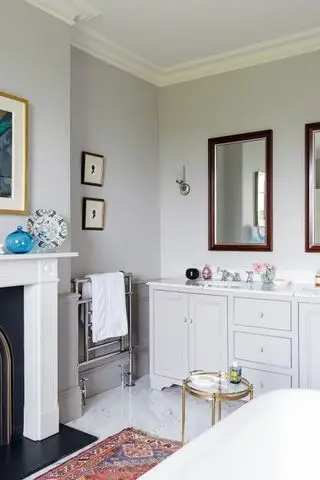 Tocador de baño tradicional gris claro con tapa de mármol en baño gris