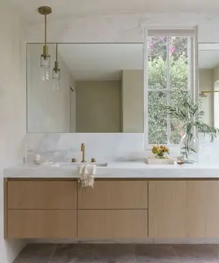 banheiro moderno com penteadeira flutuante de madeira e paredes de gesso da A Naber Design