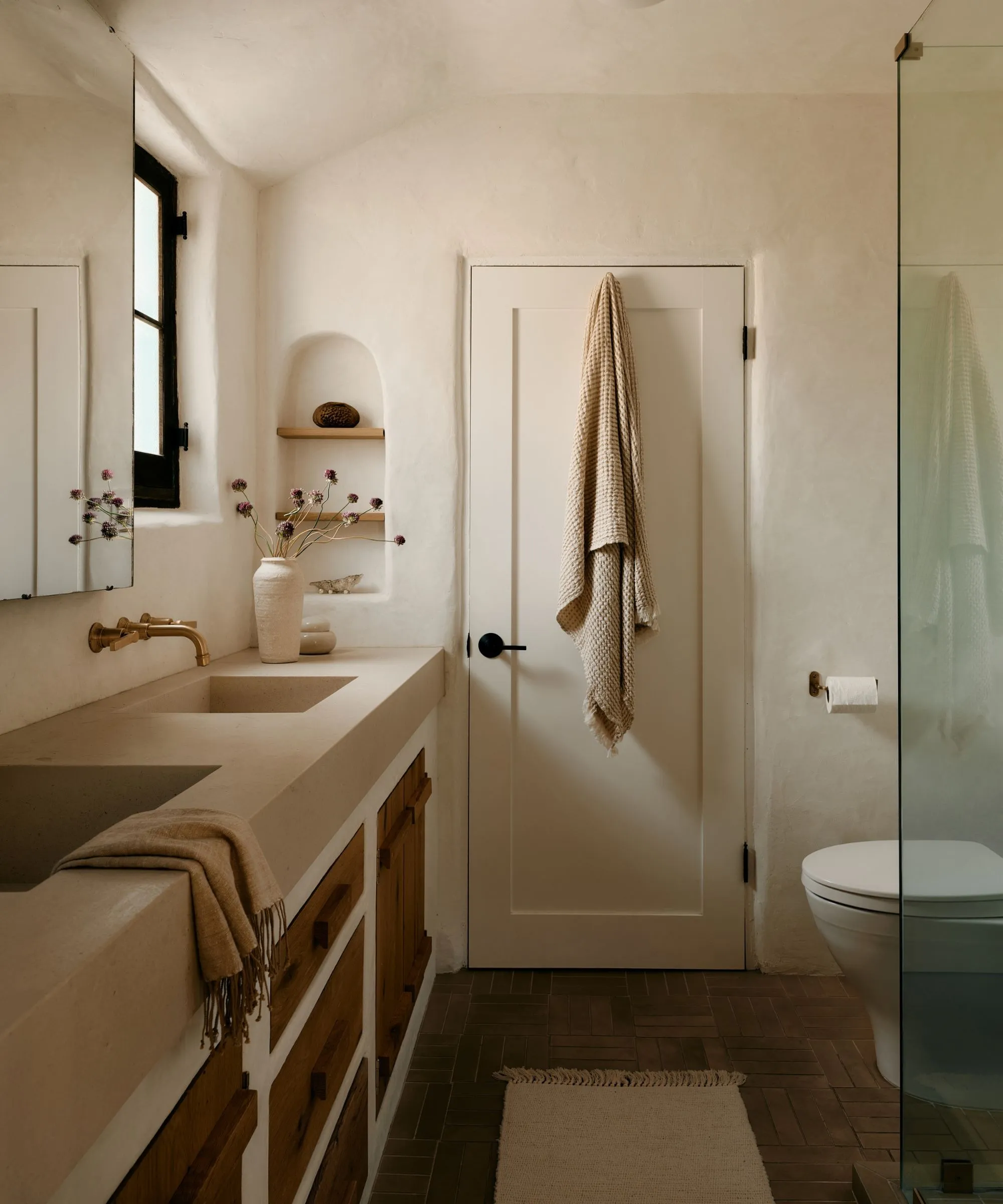 Moderní organická koupelna se sádrovými stěnami a nástěnným výklenkem pro police' loading='lazy' title=