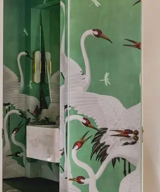 papel de parede de cegonha verde em um pequeno banheiro privativo do estúdio Duggan