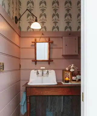 banheiro rosa e azul com paredes com painéis e papel de parede