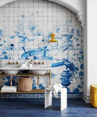 Un bagno a tema blu con piastrelle dipinte di blu e bianco con uccelli e fontane d'acqua