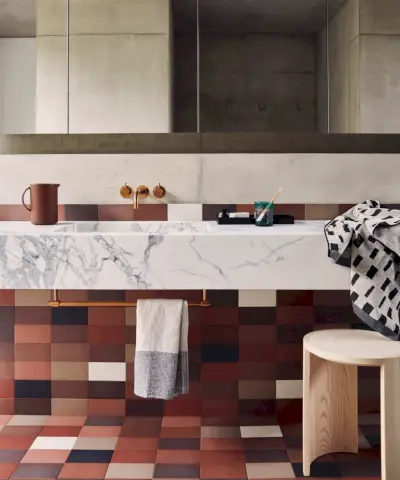 Scaffale modulare in bianco di String Furniture. Mensola posizionata sopra un piccolo lavandino, articoli da toeletta e asciugamani riposti sulla mensola, design del mobile con ante a specchio