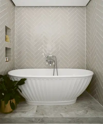Bagno con pareti e pavimenti in marmo, lavandino bianco e rubinetteria nera, mobile lavabo con portasciugamani e ripostiglio basso, nicchia accanto al lavandino con articoli da toeletta, TV integrata nella parete, specchio bianco rotondo sopra il lavandino