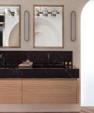 salle de bain du milieu du siècle avec comptoir en marbre noir et double lavabo