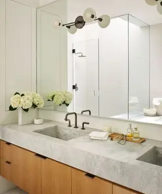 Salle de bains du milieu du siècle avec meuble vasque en bois et grand miroir