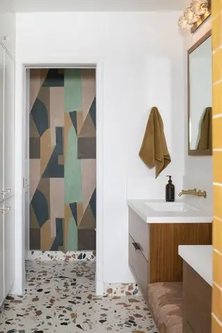 baño blanco con pisos de terrazo, mural de pared, tocadores de pared