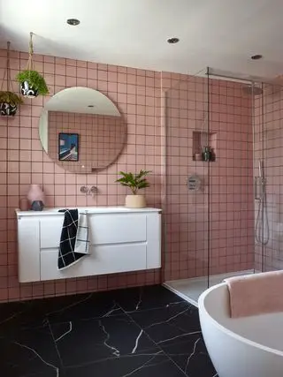 Baño familiar con azulejos rosas.