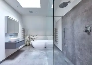 Cuarto de baño gris y blanco con ducha, tocador, lavabo grande, suelos y paredes de hormigón