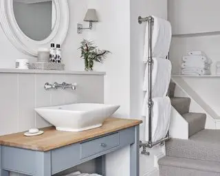 Koupelna s marnost a backsplash a věšák na ručníky s bílými ručníky