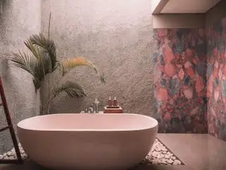 Et utendørs spabad med rødmebad og en marmorvegg med rosa, røde og grå nyanser