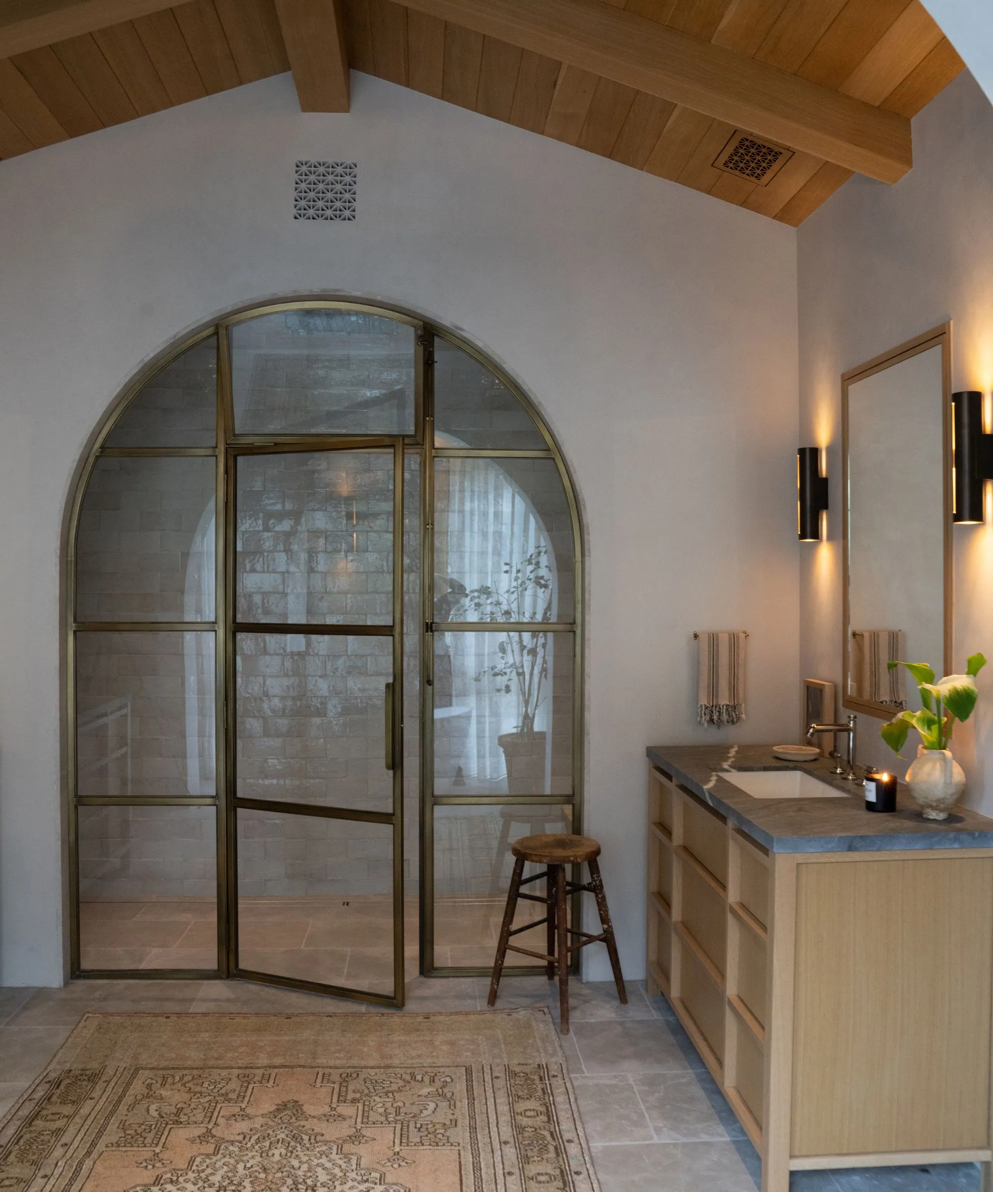 Badezimmer mit gewölbter Messingtür zur Dusche' loading='lazy' title=