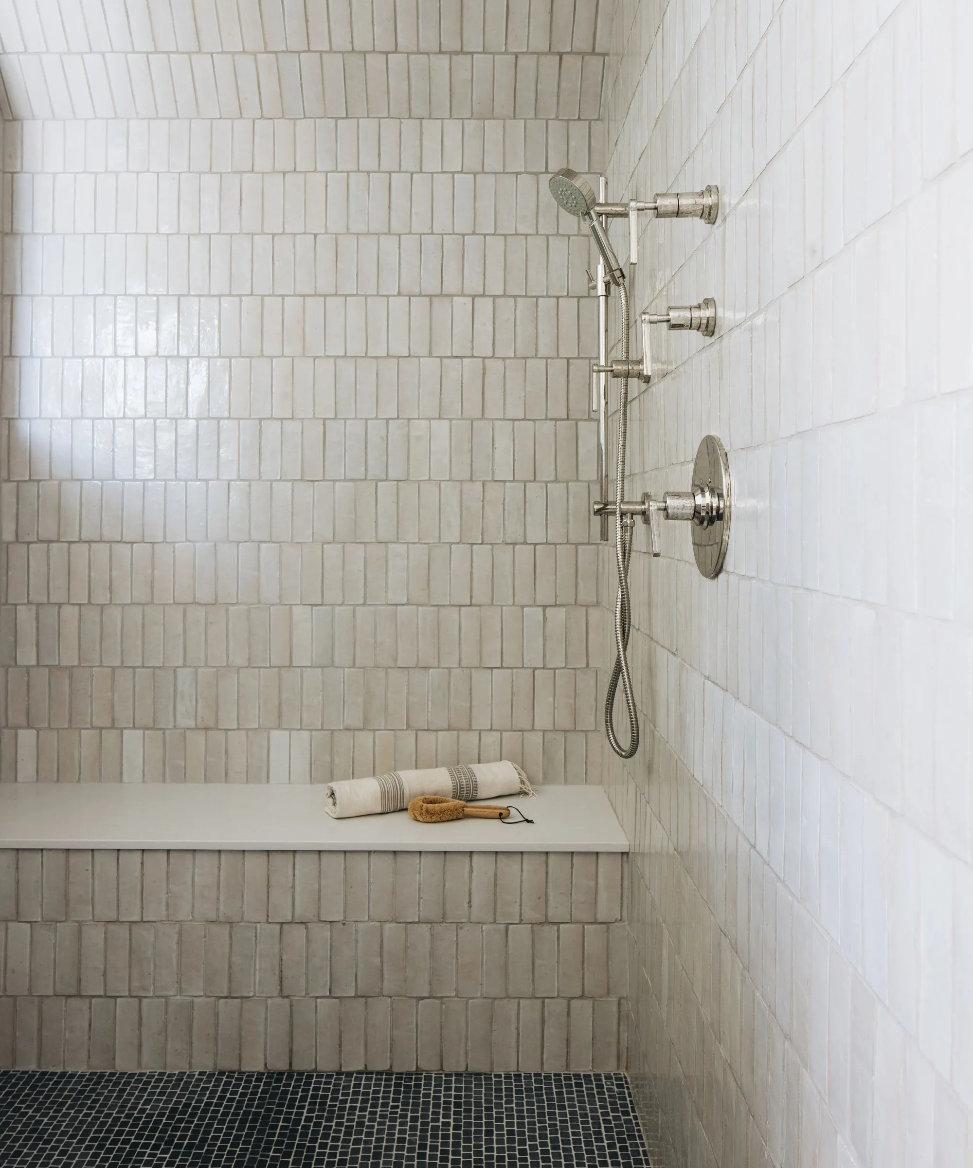 Einfaches Badezimmer mit neutralen Fliesen und Duschsitz' loading='lazy' title=