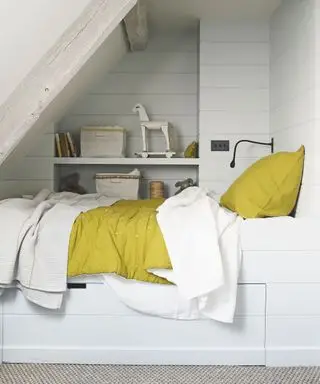 Lite soverom i en hvit hems med innebygd oppbevaring og gule detaljer.