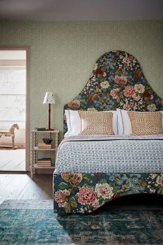 Um exemplo de ideias de cabeceira mostrando uma cama verde escura e floral