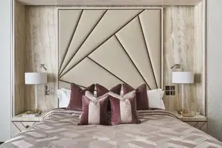 Quarto com cama fechada com cabeceira e travesseiros