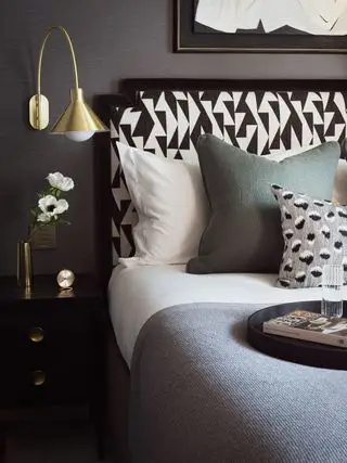 Quarto com cama fechada com cabeceira e travesseiros