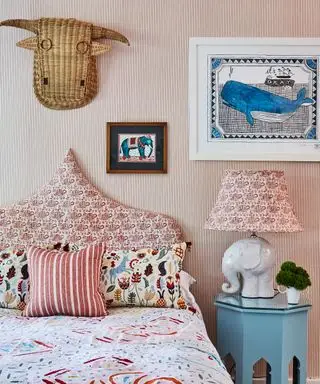 Um esquema de quarto colorido com cabeceira estofada com padrão vermelho e branco combinando com uma luminária de cabeceira