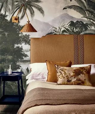 Una idea de color para el dormitorio con un mural y capas de ropa de cama y accesorios en tonos marrones