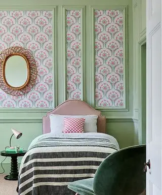 Dormitorio pintado con paneles pintados de verde y secciones de papel tapiz.