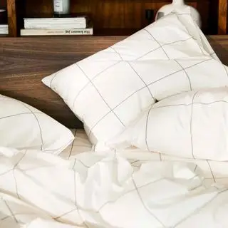 Lençóis na cama em quarto neutro