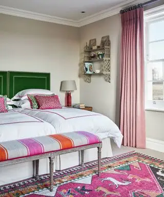 Ein Beispiel für Ideen für Schlafzimmervorhänge, das ein Schlafzimmer mit rosa Vorhängen und grünen Samtkopfteilen an zwei Einzelbetten zeigt