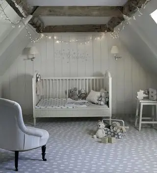 Carpetright のグレーの屋根裏部屋の寝室にある子供部屋のアイデア。斑点のあるカーペットとストリング ライトを備えています。